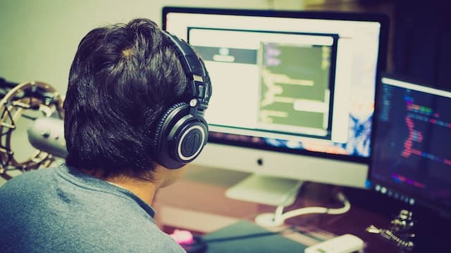 Entwickler vor mehreren Bildschirmen – KI‑gestütztes Webdesign und Automatisierung